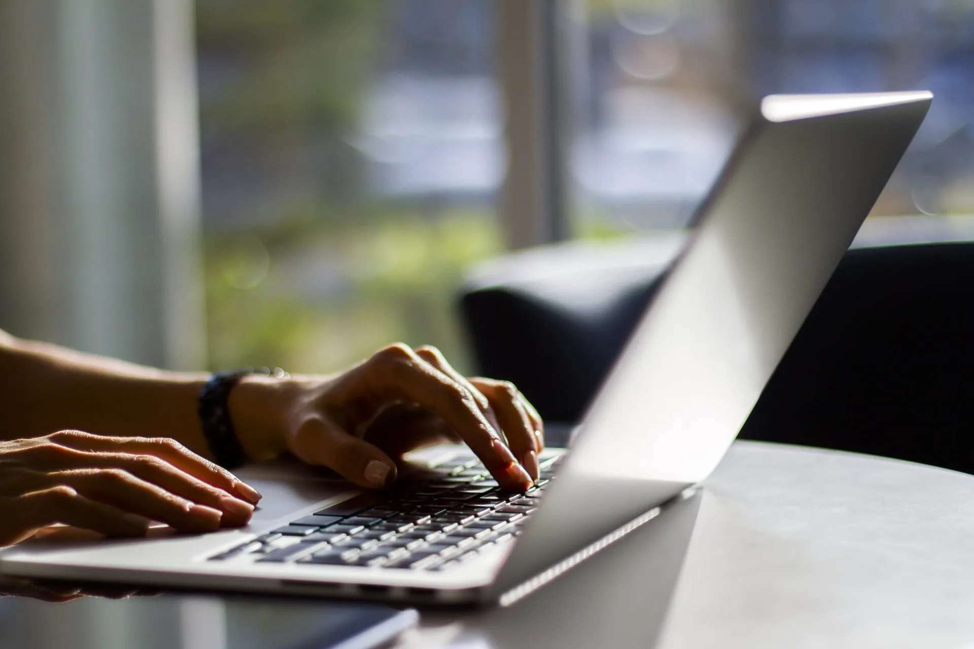 A person typing on a laptop keyboard